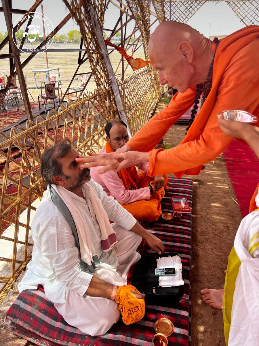 Swami Yogesh Puri Ji making tilak to a pandit.